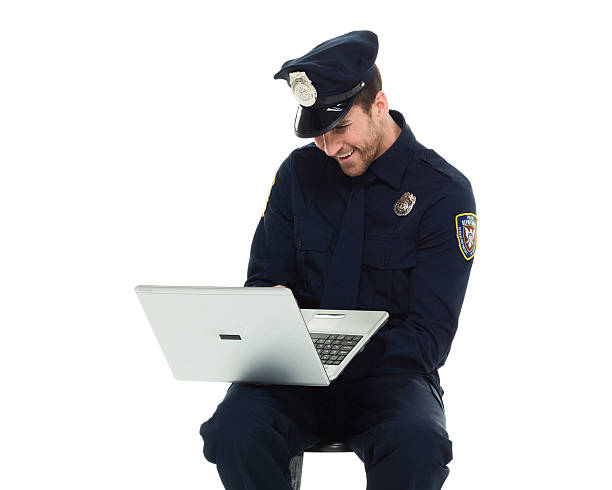 istock Smiling police working on laptop 588968428