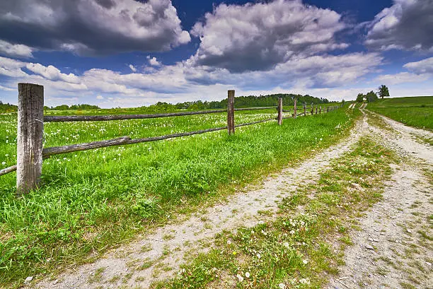 View of spring landscape with road and fence