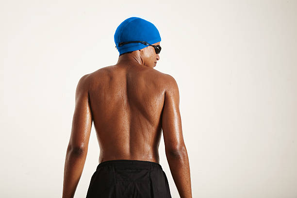 istock Back of a strong black swimmer in cap and goggles 588972914