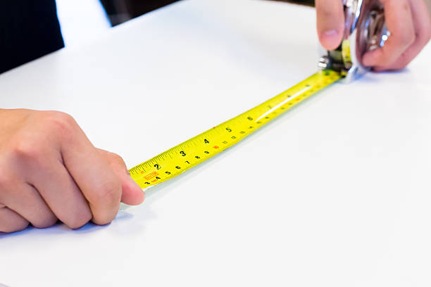 istock tape-measure in hand with white background 588973570