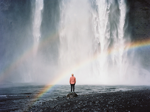 Man standing near the waterfall
