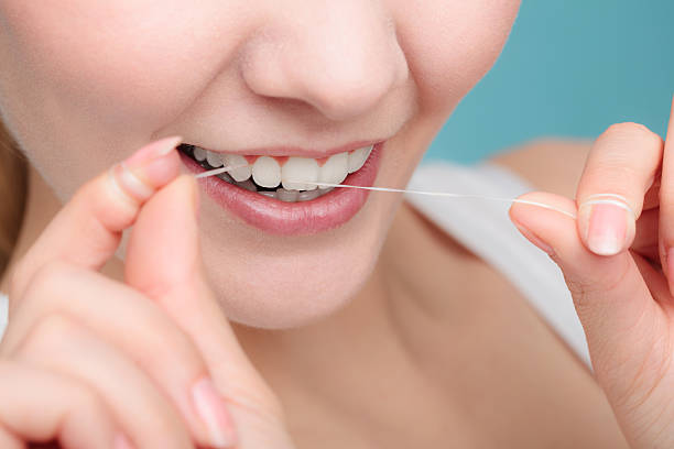 istock Woman smiling with dental floss. 588975654