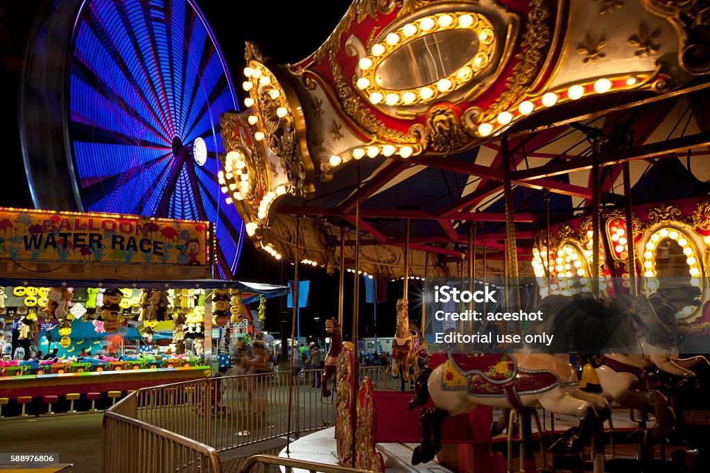 Ohio State Fair at night Columbus, OH, USA - August 1, 2016:  The midway at the Ohio State Fair is full of vibrant color at night. Amusement Park Ride Stock Photo
