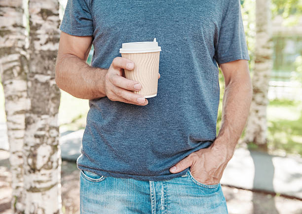 istock Man holding empty paper coffee cup. Template mock up 588977138