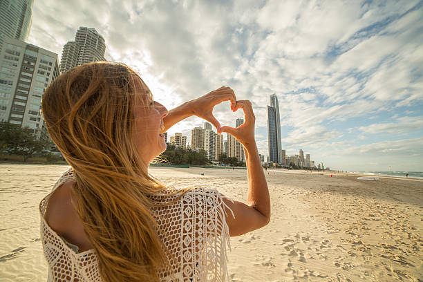 istock Girl frames Surfers paradise beach into heart shape 588979450
