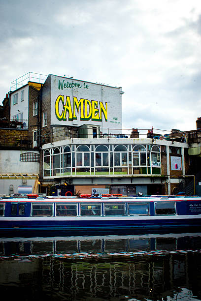 London, UK - March 6, 2016: Welcome to Camden sign on the end wall of a building overlooking the canal with a narowboat in the foreground.