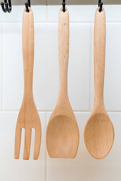 istock Wooden utensils hanging on white kitchen wall 588980406