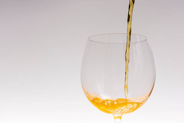istock Pouring yellow beer liquid on a wineglass 588980430