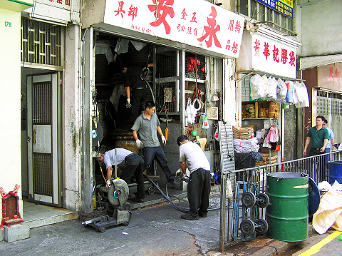 Yau Ma Tei, Hong Kong - March 23, 2004: Workers produce thick ropes in a craft business. Because of lack of space in Hong Kong, a part of the work is done directly on the footpath in front of the shop.