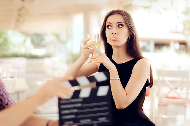 actrice contrariée tenant un verre dans la scène de film - casting glass photos et images de collection