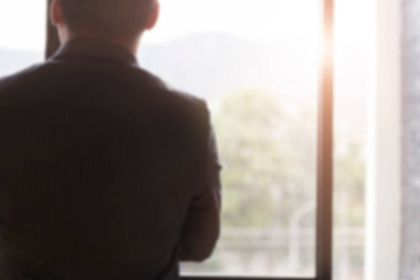 istock back of businessman in suit looking through office 588982584