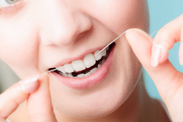 istock Woman smiling with dental floss. 588983622