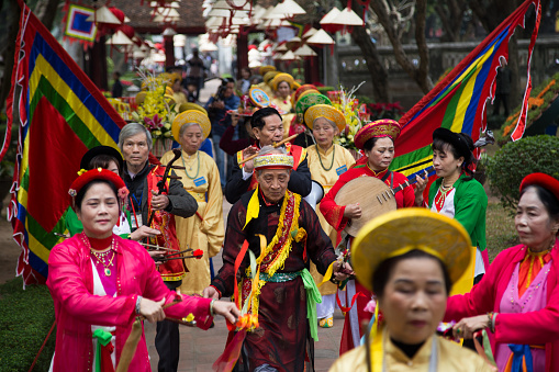 Hanoi, Vietnam - February 27, 2016: Asian civilian artists performing a public spiritual dance outdoor within a festival to welcome lunar new year at Temple of Literature in Hanoi capital, Vietnam.