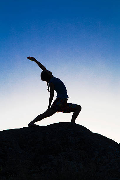 istock Young lady in yoga position on the rocks 588988318