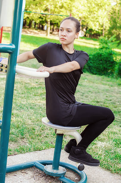 молодая женщина упражнения тренажерный зал на открытом воздухе - sports training sit ups moving up sitting стоковые фото и изображения