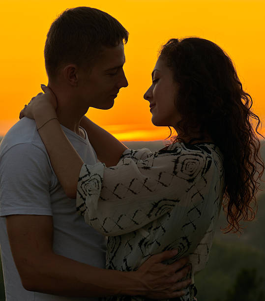 istock romantic couple looking at each other at sunset on outdoor 588993934
