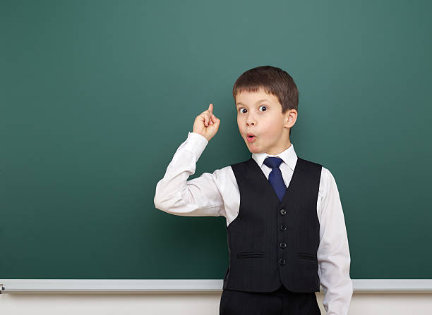 istock school student boy posing at the clean blackboard, education concept 588994132