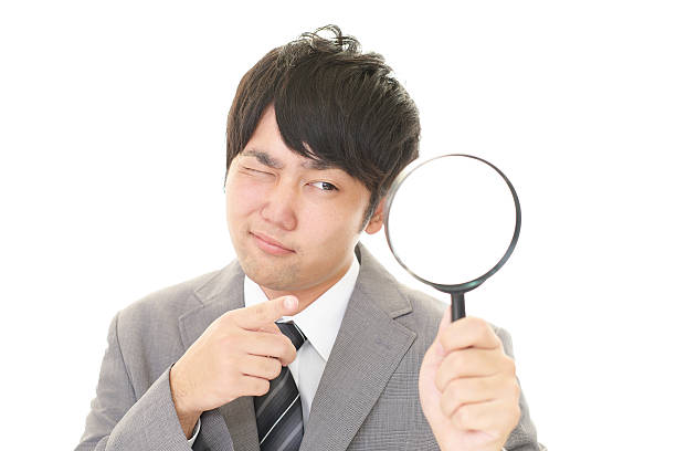 istock Asian businessman with a magnifying glass 588995048