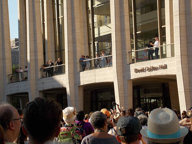 Conductor Leading Outdoor Chorus From Balcony New York, NY, USA - August 13, 2016: Conductor stands on outside balcony of concert hall leading huge crowd of volunteer vocalists during world premiere of David Lang's piece "public domain". public domain photos stock pictures, royalty-free photos & images
