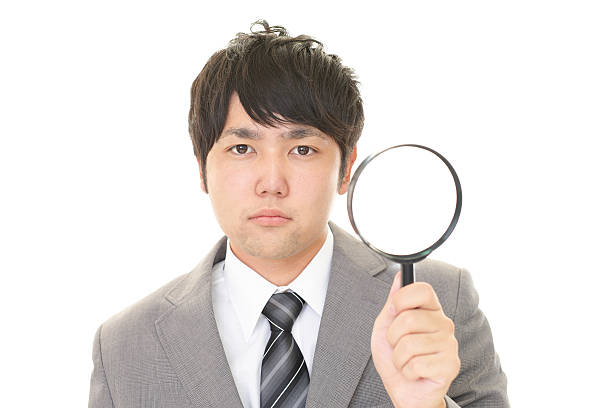 istock Asian businessman with a magnifying glass 588995650