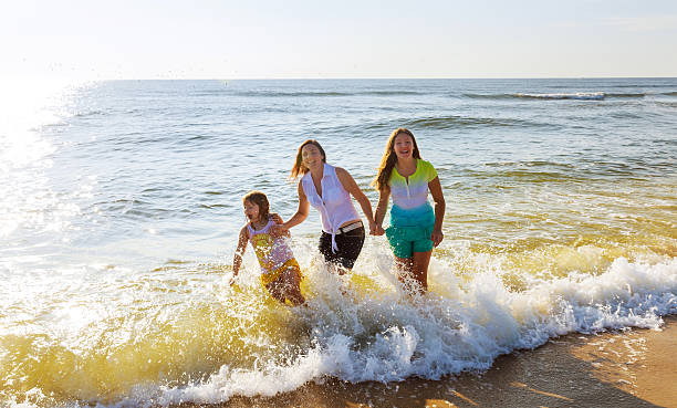 istock Mother with two daughters on the beach 589000564