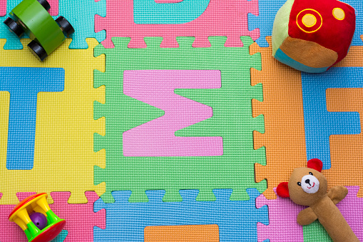 A colorful ifantil carpet with toys on top.