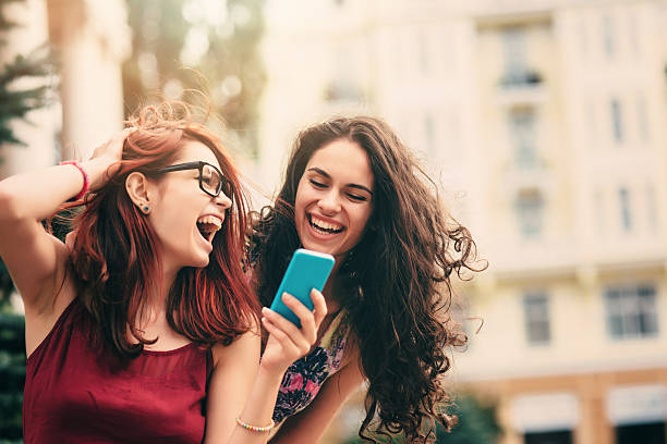 istock Two friends texting outdoor 589091780