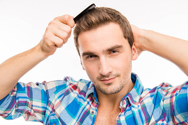 istock Handsome cheeky young man combing his hair 589094198