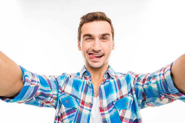 istock Handsome young man making selfie photo showing tongue 589094562