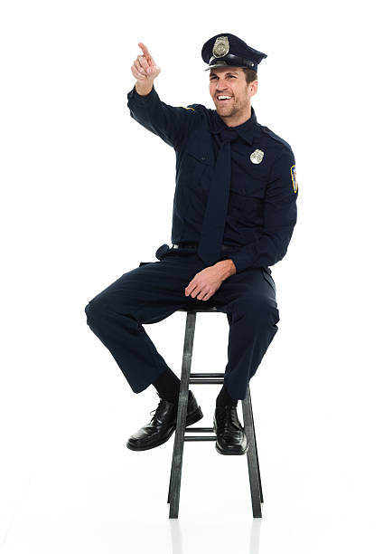 istock Cheerful police sitting on stool and pointing 589095152