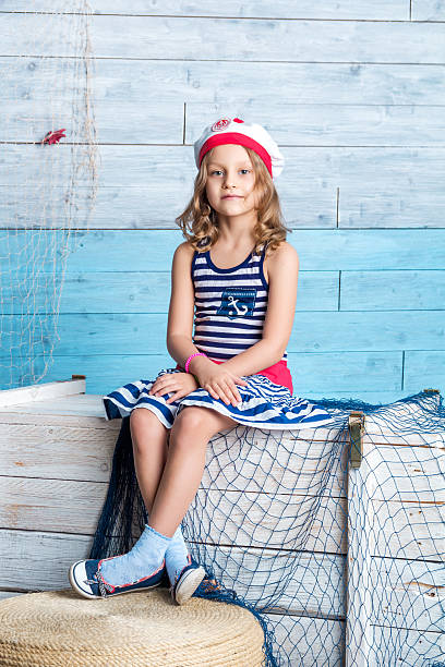 istock Little girl sailor sitting on box 589097218