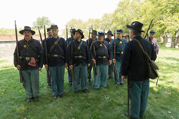 Civil War enactment New York, NY USA _ August 13, 2016: Members of 119th New York Volunteer Infantry  living history organization put on Civil War musket demonstrations at National Park Service annual Civil War heritage weekend at Governors Island civil war enactment stock pictures, royalty-free photos & images