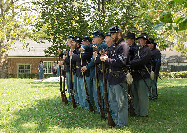 Civil War enactment New York, NY USA _ August 13, 2016: Members of 119th New York Volunteer Infantry  living history organization put on Civil War musket demonstrations at National Park Service annual Civil War heritage weekend at Governors Island civil war enactment stock pictures, royalty-free photos & images