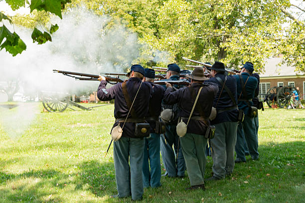 Civil War enactment New York, NY USA - August 13, 2016: Members of 119th New York Volunteer Infantry  living history organization put on Civil War musket demonstrations at National Park Service annual Civil War heritage weekend at Governors Island civil war enactment stock pictures, royalty-free photos & images