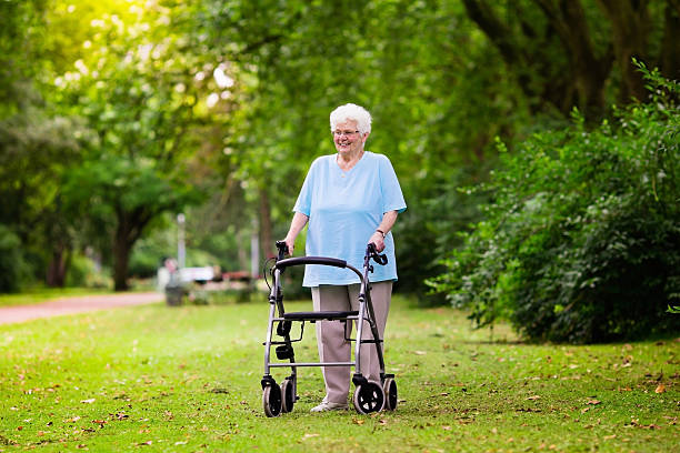 istock Senior lady with a walker enjoying a walk in park 589099588