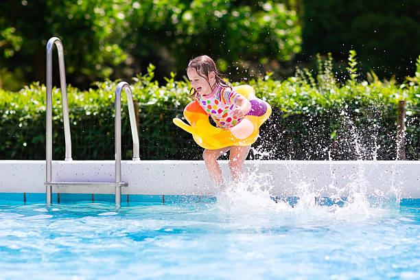 istock Little girl jumping into swimming pool 589100186