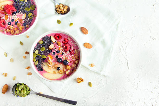 Smoothie bowl Smoothie bowl with fresh berries, nuts, seeds and homemade granola for healthy breakfast coconut milk photos stock pictures, royalty-free photos & images