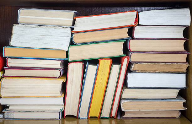 istock Books on grunge wooden table desk shelf in library. Back 589107116
