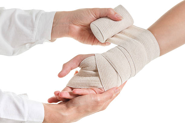 istock Wrapping elastic support bandage on wrist, hand trauma. Isolated white 589107234