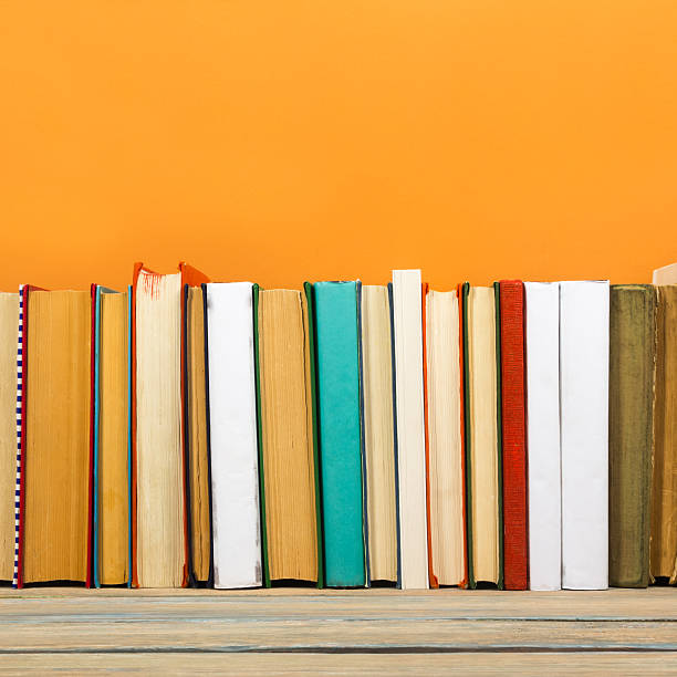 istock Books on grunge wooden table desk shelf in library. Back 589107324