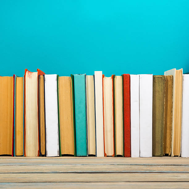 istock Books on grunge wooden table desk shelf in library. Back 589107504