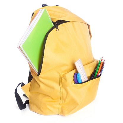 Backpack full of school supplies isolated on white