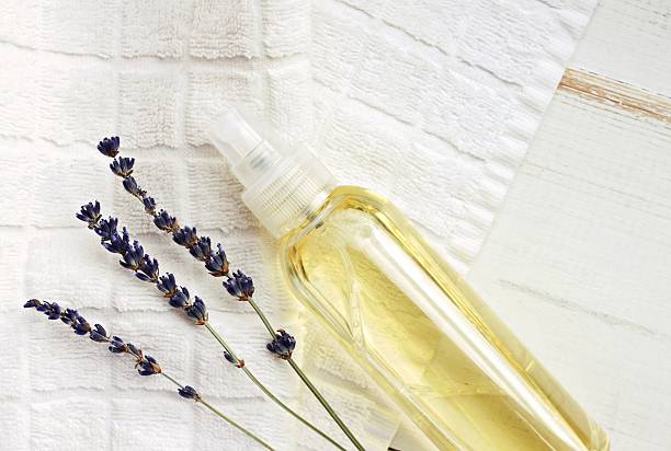 rocíe botella de aceite sobre toalla con lavanda - flower single flower spa white fotografías e imágenes de stock