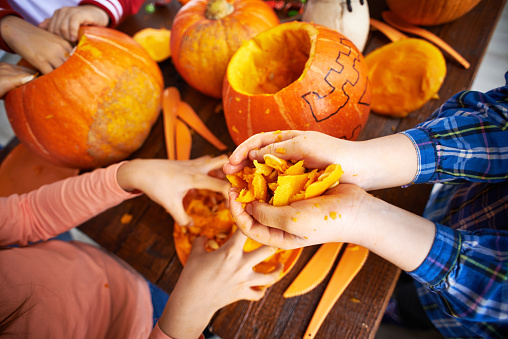 Children removing pulp from pumpkins to make Jack Oâlanterns