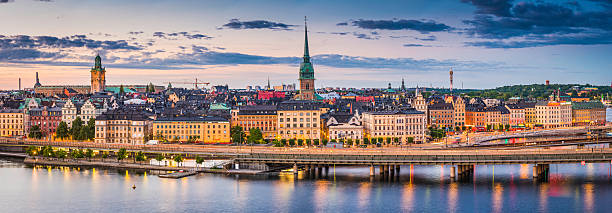 Stockholm Gamla Stan waterfront cityscape illuminated panorama at sunset Sweden High angle panoramic view across the rooftops and spires of Gamla Stan as the dusk lights illuminate the heart of Stockholm, Sweden's vibrant capital city. sodermalm photos stock pictures, royalty-free photos & images