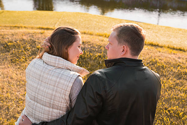 istock Romantic couple relaxing on the river dock in autumn park 589114444