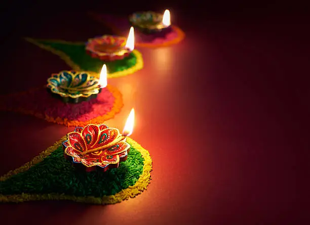 Colorful clay diya lamps lit during diwali celebration.