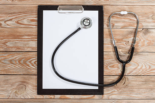 istock Medical clipboard and stethoscope on wooden table background. 589115272