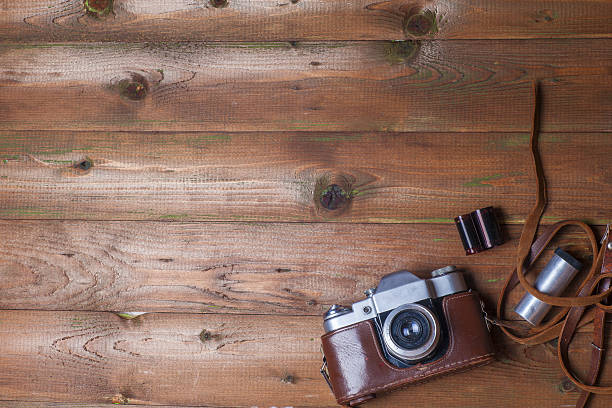 istock Old retro camera on vintage wooden boards abstract background. 589116904