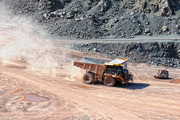 istock dumper truck driving around in an open pit mine. 589117142